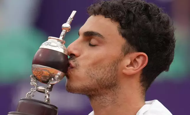 Argentina's Francisco Cerundolo kisses the trophy after defeating Italy's Luciano Darderi in an Argentina Open ATP men's singles final tennis match at Guillermo Vilas Stadium in Buenos Aires, Argentina, Sunday, Feb. 15, 2026. (AP Photo/Gustavo Garello)