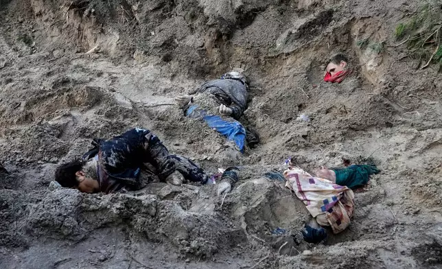 EDS NOTE: GRAPHIC CONTENT - FILE - The bodies of people lie half-buried in a mass grave in Motyzhyn close to Kyiv, Ukraine, Monday, April 4, 2022. (AP Photo/Efrem Lukatsky)