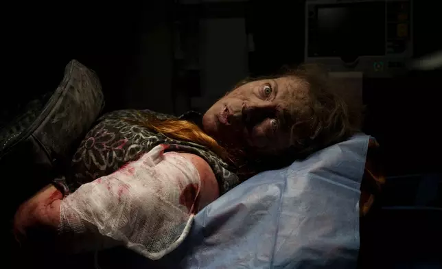FILE - A resident wounded after a Russian attack, lies inside an ambulance before being taken to a hospital in Kherson, southern Ukraine, Thursday, Nov. 24, 2022. (AP Photo/Bernat Armangue, File)