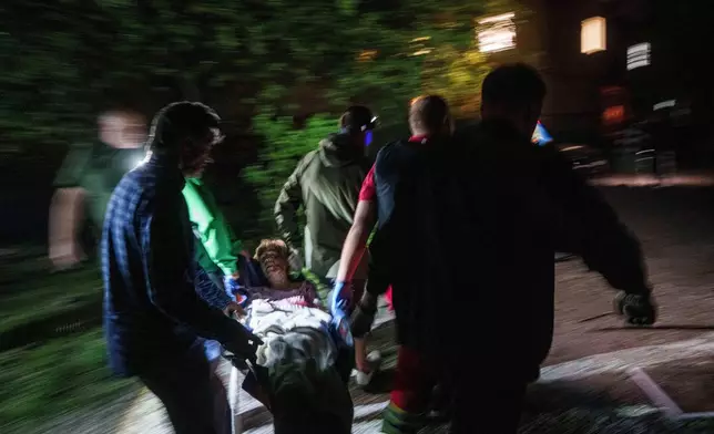 FILE - Rescue workers carry an injured woman on a stretcher out of a house destroyed by a Russian airstrike in a residential neighbourhood in Kyiv, Ukraine, on Thursday, April 24, 2025. (AP Photo/Evgeniy Maloletka, File)