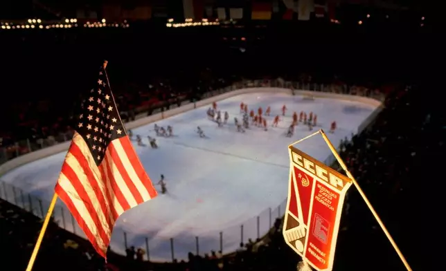 FILE - In this Feb. 22, 1980, file photo, an American flag and Soviet team banner are shown above the hockey rink where the the United States and Soviets played a medal round hockey match at the 1980 Winter Olympics in Lake Placid, N.Y. (AP Photo/File)