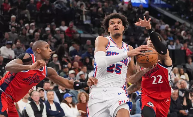 Philadelphia 76ers forward Dominick Barlow (25) drives to the basket past Los Angeles Clippers guard Jordan Miller (22) and guard Kris Dunn (8) during the first half of an NBA basketball game Monday, Feb. 2, 2026, in Inglewood, Calif. (AP Photo/Jae C. Hong)