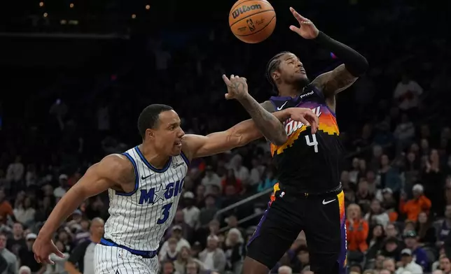 Orlando Magic guard Desmond Bane fouls Phoenix Suns guard Jalen Green (4) during the second half of an NBA basketball game, Saturday, Feb. 21, 2026, in Phoenix. (AP Photo/Rick Scuteri)
