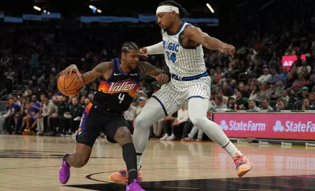 Phoenix Suns guard Jalen Green (4) shields Orlando Magic center Wendell Carter Jr. from the ball during the second half of an NBA basketball game, Saturday, Feb. 21, 2026, in Phoenix. (AP Photo/Rick Scuteri)