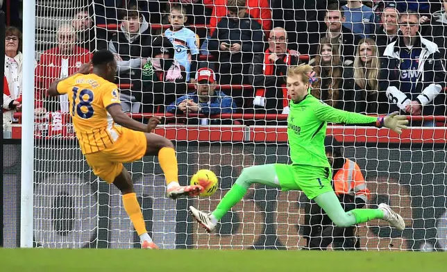 Brighton and Hove Albion's Danny Welbeck scores their side's second goal of the game past Brentford's goalkeeper Caoimhin Kelleher during their English Premier League soccer match in London Saturday, Feb. 21, 2026. (Peter Tarry/PA via AP)