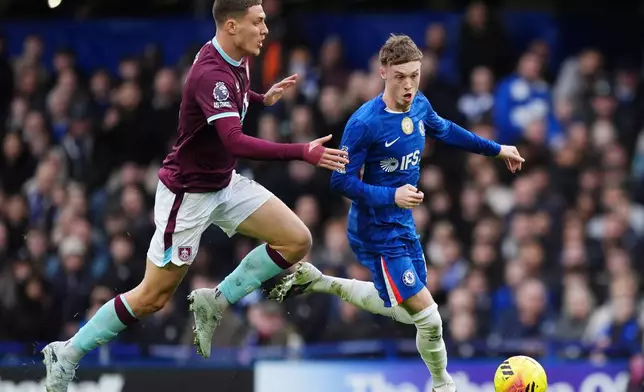 Burnley's Maxime Esteve, left, and Chelsea's Cole Palmer battle for the ball during their English Premier League soccer match in London, Saturday, Feb. 21, 2026. (Ben Whitley/PA via AP)