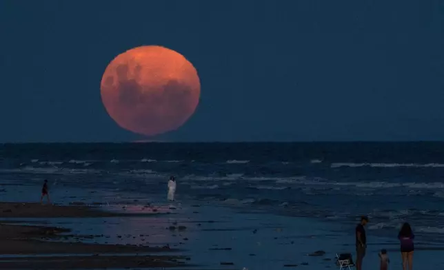 A full moon rises over Montevideo, Uruguay, Sunday, Feb. 1, 2026. (AP Photo/Matilde Campodonico)