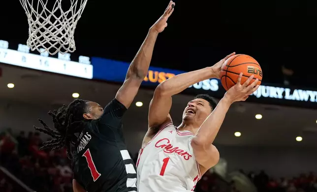 Houston guard Isiah Harwell, right, shoots over Cincinnati guard Day Day Thomas, left, during the second half of an NCAA college basketball game Saturday, Jan. 31, 2026, in Houston. (AP Photo/Kevin M. Cox)