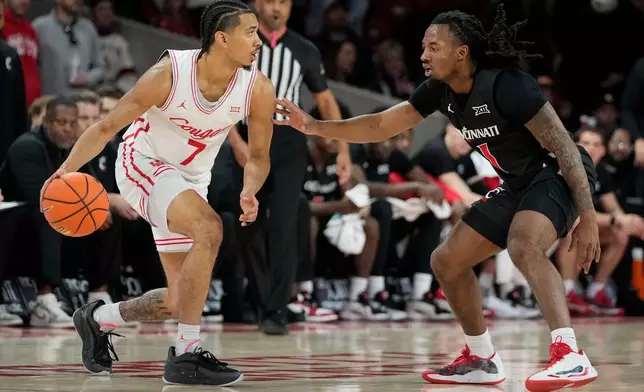 Houston guard Milos Uzan (7) is defended by Cincinnati guard Day Day Thomas (1) during the first half of an NCAA college basketball game Saturday, Jan. 31, 2026, in Houston. (AP Photo/Kevin M. Cox)