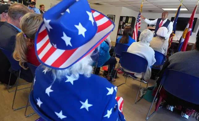 Roger Phillips, left, wears a United States flag inspired outfit as he listens to U.S. Rep. Wesley Hunt, R-Texas, speak at a campaign event Monday, Feb. 16, 2026, in Dallas. (AP Photo/Julio Cortez)