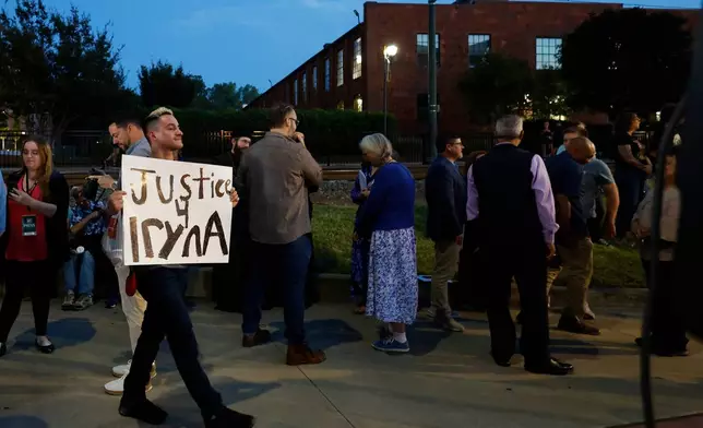 FILE - Michael Bermudez of Spartanburg, S.C., holds a sign at a vigil honoring the life of Iryna Zarutska, who was fatally stabbed on a commuter train last month, Monday, Sept. 22, 2025, in Charlotte, N.C. (AP Photo/Nell Redmond, File)