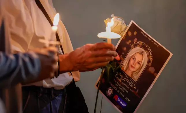 FILE - Community members hold candles as they gather for a vigil honoring the life of Iryna Zarutska, who was fatally stabbed on a commuter train last month, Monday, Sept. 22, 2025, in Charlotte, N.C. (AP Photo/Nell Redmond, File)