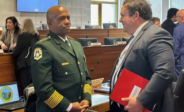 Mecklenburg County Sheriff Garry McFadden, left, speaks with state Rep. Eric Ager, D-Buncombe, during a break in the North Carolina House Select Committee on Oversight and Reform meeting at the Legislative Building in Raleigh, N.C., Monday, Feb. 9, 2026 (AP Photo/Gary D. Robertson)