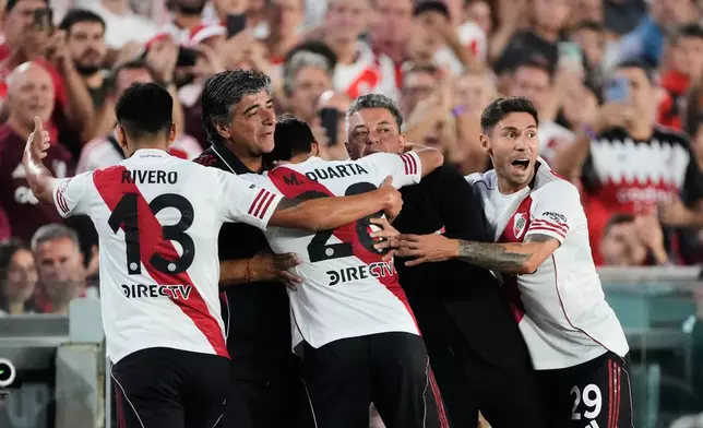 River Plate coach Marcelo Gallardo, second from right, is embraced by player Lucas Martínez Quarta after he scored his side's first goal against Banfield, during an Argentine soccer league match, Gallardo's last as manager, in Buenos Aires, Argentina, Thursday, Feb. 26, 2026. (AP Photo/Gustavo Garello)