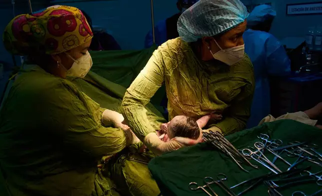 Doctors assist in a birth at the Ramón González Coro Maternity Hospital in Havana, Cuba, Friday, Feb. 20, 2026. (AP Photo/Ramon Espinosa)