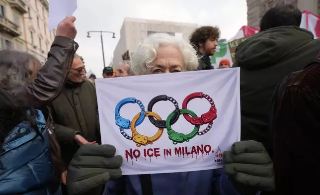 People take part in an Anti-ICE demonstration, ahead of the 2026 Winter Olympics, in Milan, Italy, Saturday, Jan. 31, 2026. (AP Photo/Antonio Calanni)