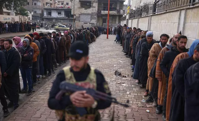 FILE - Former Syrian Democratic Forces members line up at a government-run reconciliation center to obtain official clearance documents stating they have left the group, a move aimed at avoiding further legal prosecution, in Raqqa, northeastern Syria, Feb. 1, 2026. (AP Photo/Ghaith Alsayed, File)