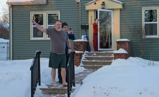 FILE - Residents film and yell at federal agents to leave their neighborhood while agents conduct immigration enforcement operations in a neighborhood in Minneapolis, Feb. 2, 2026. (AP Photo/Ryan Murphy, File)
