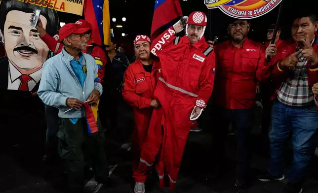 FILE - A PDVSA worker of the state-owned oil company carries a cutout of former President Nicolas Maduro dressed as an oil worker during a rally to back an oil reform bill proposed by acting President Delcy Rodriguez to loosen state control and open the industry to private and foreign investment in Caracas, Venezuela, Jan. 29, 2026. (AP Photo/Ariana Cubillos, File)