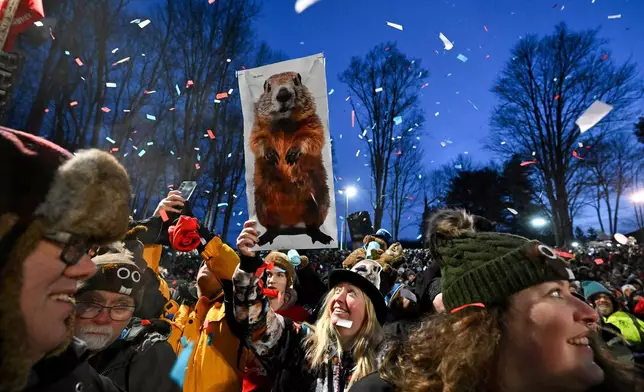 FILE - People take part in the festivities while waiting for Punxsutawney Phil, the weather prognosticating groundhog, to come out and make his prediction during the 139th celebration of Groundhog Day on Gobbler's Knob in Punxsutawney, Pa., Feb. 2, 2025. (AP Photo/Barry Reeger, File)