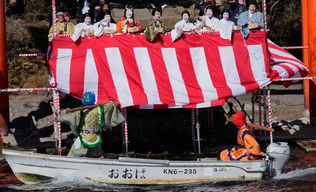 Locals dressed as Japanese folklore figures throw lucky beans to 'Oni', or demon-like figures, at Lake Ashi near Hakone Shrine during the annual Bean Throwing Festival in Hakone, Japan, Tuesday, Feb. 3, 2026. (AP Photo/Eugene Hoshiko)
