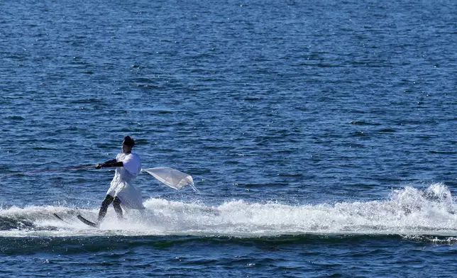 A student depicting a shrine priest skims across the water on water skis during the annual Bean Throwing Festival in Lake Ashi, near Hakone Shrine, Japan, Tuesday, Feb. 3, 2026. (AP Photo/Eugene Hoshiko)