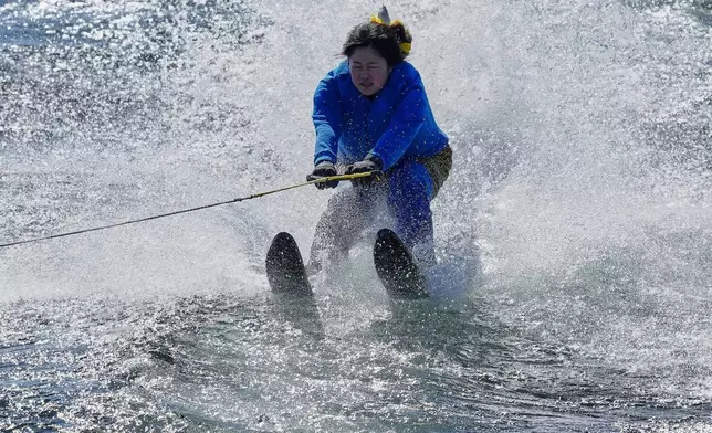 A student dressed as an 'Oni', demon-like figures in Japanese folklore, water skis during the annual Bean Throwing Festival near Hakone Shrine in Hakone, Japan, Tuesday, Feb. 3, 2026. (AP Photo/Eugene Hoshiko)