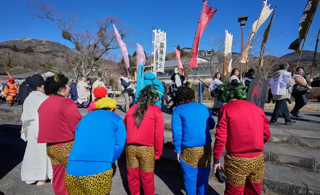 Students dressed as Oni, or demon-like figures in Japanese folklore, bow to participants marching to Lake Ashi, near Hakone Shrine during the annual Bean Throwing Festival in Hakone, Japan, Tuesday, Feb. 3, 2026. (AP Photo/Eugene Hoshiko)