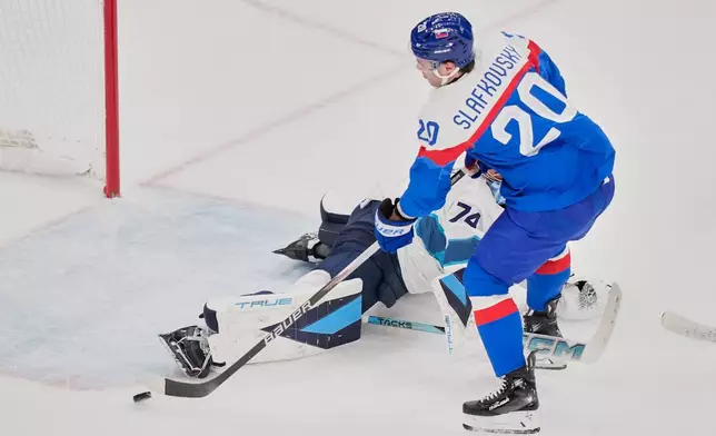 Slovakia's Juraj Slafkovsky (20) scores her side's opening goal during a preliminary round match of men's ice hockey between Slovakia and Finland at the 2026 Winter Olympics, in Milan, Italy, Wednesday, Feb. 11, 2026. (AP Photo/Petr David Josek)