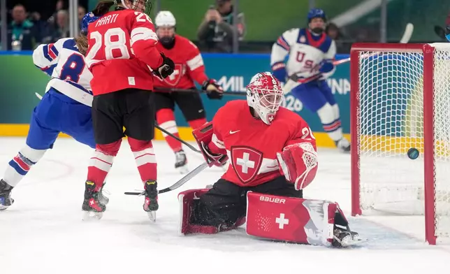United States' Haley Winn, left, scores her side's opening goal during a preliminary round match of women's ice hockey between Switzerland and United States at the 2026 Winter Olympics, in Milan, Italy, Monday, Feb. 9, 2026. (AP Photo/Hassan Ammar)