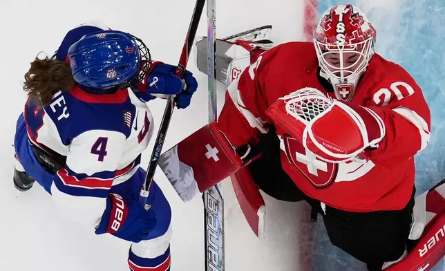 Switzerland's Andrea Brandli makes a save against United States' Caroline Harvey during a preliminary round match of women's ice hockey between the United States and Switzerland at the 2026 Winter Olympics, in Milan, Italy, Monday, Feb. 9, 2026. (AP Photo/Petr David Josek)