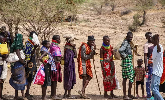 Locals queue to receive relief food as severe drought continues, in Lomekulu Village, Turkana County, Kenya, Sunday, Feb. 8, 2026. (AP Photo/Patrick Ngugi)