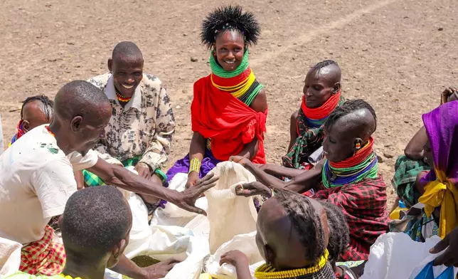 Locals share food rations distributed by World Vision Kenya as severe drought continues, in Nalemkais Village, Turkana County, Kenya, Sunday, Feb. 8, 2026. (AP Photo/Patrick Ngugi)