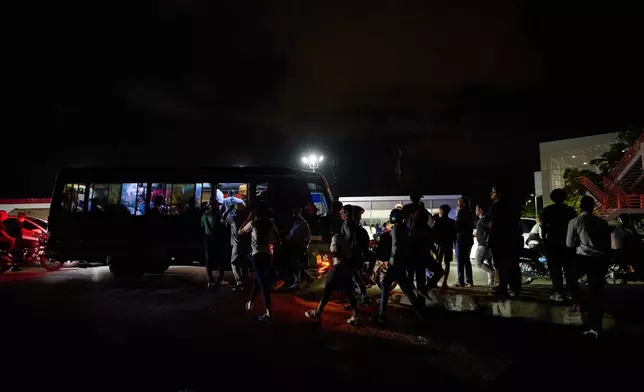 People wait to take public transportation during a blackout in Santo Domingo, Dominican Republic, Monday, Feb. 23, 2026. (AP Photo/Ricardo Hernandez)