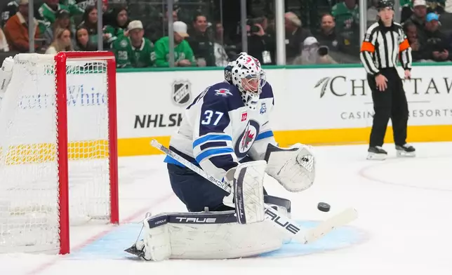 Winnipeg Jets goaltender Connor Hellebuyck blocks a shot by the Dallas Stars during the first period of an NHL hockey game Monday, Feb. 2, 2026, in Dallas. (AP Photo/Julio Cortez)