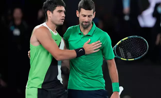 Carlos Alcaraz of Spain, left, and Novak Djokovic of Serbia embrace after Alcaraz won the men's singles final at the Australian Open tennis championship in Melbourne, Australia, Sunday, Feb. 1, 2026. (AP Photo/Asanka Brendon Ratnayake)