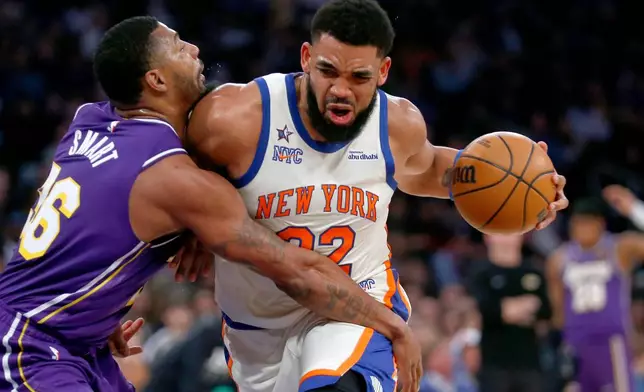 Los Angeles Lakers guard Marcus Smart, left, defends against New York Knicks center Karl-Anthony Towns, right, during the first half of an NBA basketball game, Sunday, Feb. 1, 2026, in New York. (AP Photo/John Munson)