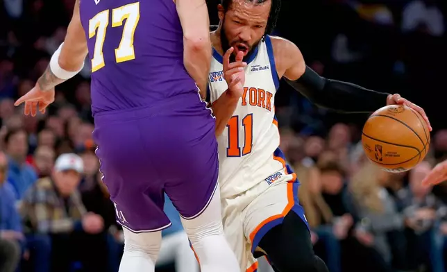 Los Angeles Lakers guard Luka Doncic, left, defends against New York Knicks guard Jalen Brunson, right, during the first half of an NBA basketball game, Sunday, Feb. 1, 2026, in New York. (AP Photo/John Munson)