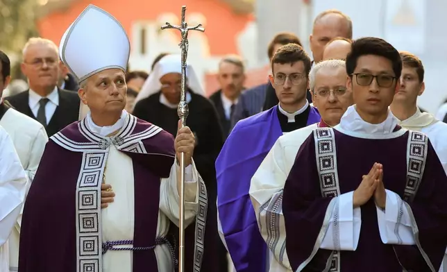 Pope Leo XIV, left, arrives, with bishops and cardinals in a penitential procession marking the start of the Catholic Lent, at the Basilica of Santa Sabina in Rome, Wednesday, Feb. 18, 2026, where he will preside over Ash Wednesday Mass. (AP Photo/Riccardo De Luca)