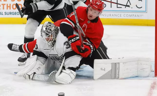 Carolina Hurricanes' Jackson Blake (53) gets tied up with Los Angeles Kings goaltender Anton Forsberg, left, during the second period of an NHL hockey game in Raleigh, N.C., Sunday, Feb. 1, 2026. (AP Photo/Karl DeBlaker)