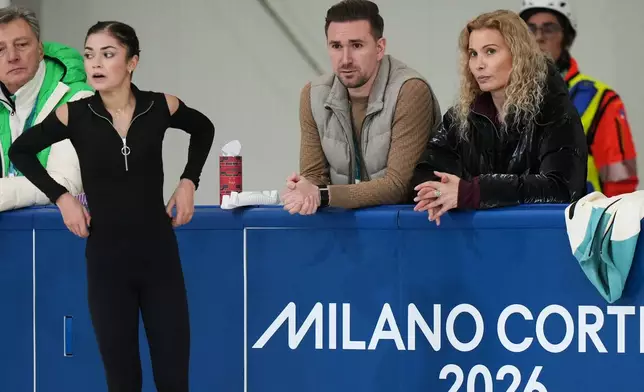 Individual Neutral Athlete Adeliia Petrosian, left, speaks with choreographer Daniil Gleikhengauz, center, and coach Eteri Tutberidze, during a figure skating practice session at the 2026 Winter Olympics, in Milan, Italy, Monday, Feb. 16, 2026. (AP Photo/Stephanie Scarbrough)