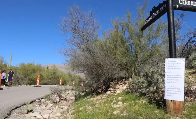 A sign posted along the road to Nancy Guthrie's home on Sunday, Feb. 22, 2026, in Tucson, Ariz., asks media to work elsewhere. (AP Photo/Felicia Fonseca)
