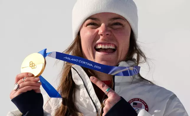 United States' Breezy Johnson shows her gold medal in the alpine ski women's downhill race, at the 2026 Winter Olympics, in Cortina d'Ampezzo, Italy, Sunday, Feb. 8, 2026. (AP Photo/Andy Wong)