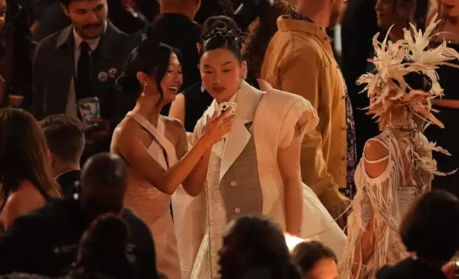 Audrey Nuna, center, and Rei Ami, right, speak in the audience during the 68th annual Grammy Awards on Sunday, Feb. 1, 2026, in Los Angeles. (AP Photo/Chris Pizzello)