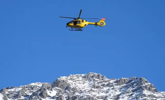 A rescue helicopter flies past ahead of an alpine ski men's downhill portion of a team combined race, at the 2026 Winter Olympics, in Bormio, Italy, Monday, Feb. 9, 2026. (AP Photo/Rebecca Blackwell)