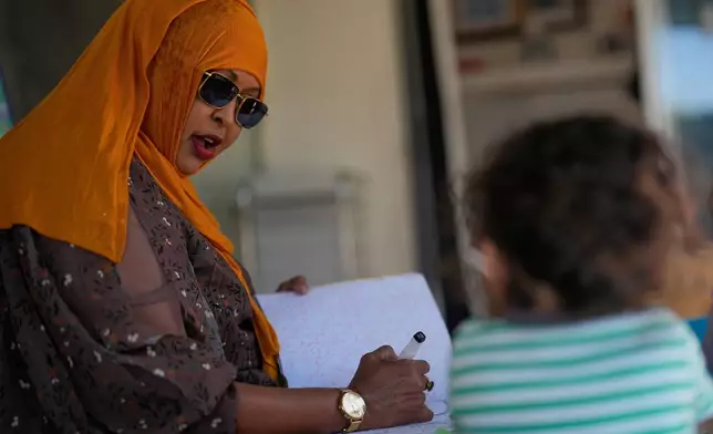 Samsam Khalif works with children at her home-based child care center Friday, Jan. 30, 2026, in San Diego. (AP Photo/Gregory Bull)