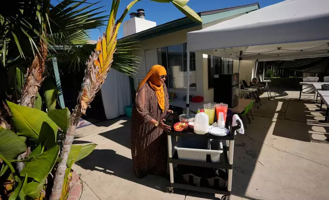 Samsam Khalif prepares for meal time at her home-based child care center Friday, Jan. 30, 2026, in San Diego. (AP Photo/Gregory Bull)