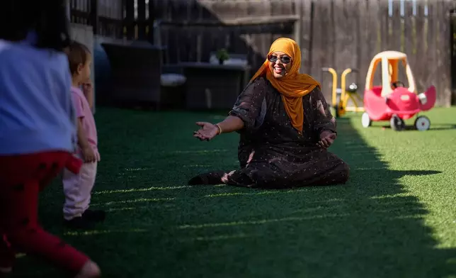 Samsam Khalif plays with children at her home-based child care center Friday, Jan. 30, 2026, in San Diego. (AP Photo/Gregory Bull)