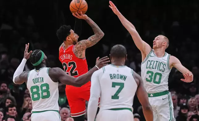 Chicago Bulls guard Anfernee Simons (22) takes a shot while surrounded by Boston Celtics during the first half of an NBA basketball game, Wednesday, Feb. 11, 2026, in Boston. (AP Photo/Charles Krupa)