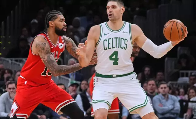 Boston Celtics center Nikola Vucevic (4) looks to pass while pressured by Chicago Bulls center Nick Richards during the first half of an NBA basketball game, Wednesday, Feb. 11, 2026, in Boston. (AP Photo/Charles Krupa)